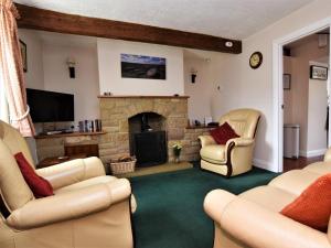 a living room with two chairs and a fireplace at 2 Bed in Eyam oc-pk812 in Eyam