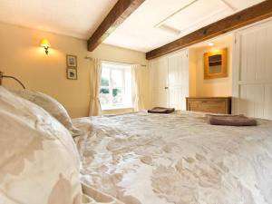a bedroom with a large white bed with a window at 2 Bed in Eyam oc-pk812 in Eyam