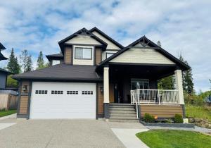 a house with a white garage door at True Haven Deluxe in Prince George