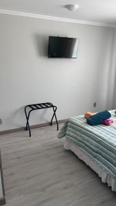 a bedroom with a bed and a tv on the wall at Florencia Boutique Cabin in Olmué