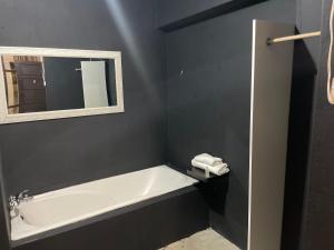 a bathroom with a white bath tub and a mirror at Ocean Garden GuestHouse in Ispongo +89 photos