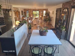 a white table and chairs in a room with a kitchen at Villa MOUREZEVA in Mourèze