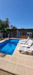 a swimming pool with lounge chairs next to a building at Maranatha in Rufino