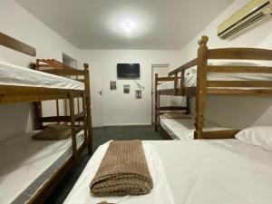a room with three bunk beds and a flat screen tv at Cantinho do Viajante in Arraial do Cabo