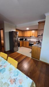 a large kitchen with a table and a refrigerator at Jardim do Sol in Jardim do Mar