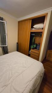 a bedroom with a white bed and a closet at Jardim do Sol in Jardim do Mar