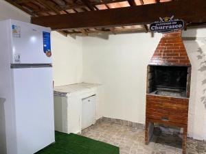 a kitchen with a refrigerator and a brick oven at Cantinho do Viajante in Arraial do Cabo +24 photos