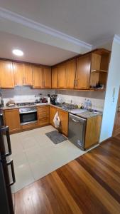 a kitchen with wooden cabinets and a stove top oven at Jardim do Sol in Jardim do Mar