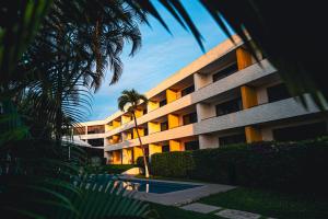 a building with a palm tree and a swimming pool at Casa Francisco in Cuernavaca