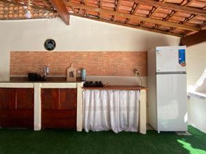 a kitchen with a white refrigerator and a counter at Cantinho do Viajante in Arraial do Cabo