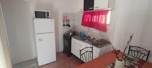 a small kitchen with a white refrigerator and a table at Apartamento 2 Guazuvira in Guazuvira