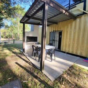 a patio with a table and chairs under a pavilion at Apartamento 2 Guazuvira in Guazuvira
