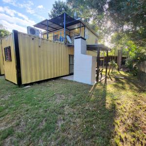 a yellow house with a roof on top of a yard at Apartamento 2 Guazuvira in Guazuvira