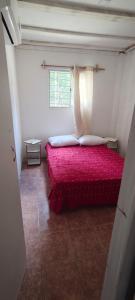 a bedroom with a red bed with a window at Apartamento 2 Guazuvira in Guazuvira