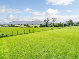 a field of green grass with a fence at 1 Bed in Keswick oc-82476 in Bassenthwaite +3 photos