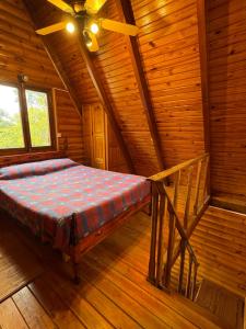 a bedroom with a bed in a wooden cabin at Cabaña in La Rioja