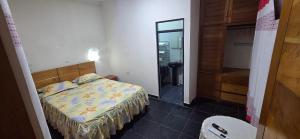 a small bedroom with a bed and a mirror at Ximena's House in Iquitos