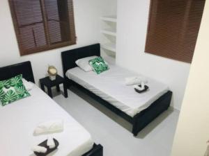 two twin beds in a room withskirts at Villa Lourdes in Rousseau