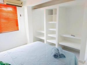 a white bedroom with a bed and white shelves at Villa Lourdes in Rousseau