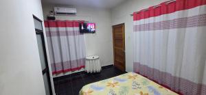 a small room with a bed and a television at Ximena's House in Iquitos