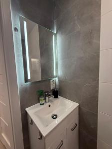 a bathroom with a sink and a mirror at Apartament Centrum nr 8 in Radom +4 photos
