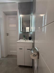 a white bathroom with a sink and a toilet at Apartament Centrum nr 8 in Radom