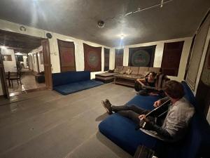 two people sitting on a couch in a living room at Intihuatana Hostel in Pisac +113 photos
