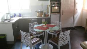 a kitchen with a table and chairs in a kitchen at Charmant logement in Lamentin