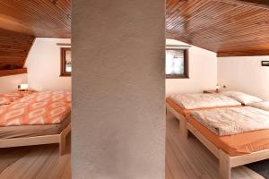 two beds in a bedroom with wooden ceilings at Chata Anna Tatranská Štrba in Štrba