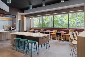 a restaurant with green stools and a large window at Tru By Hilton Miramar in Miramar