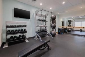 a gym with a bench and a flat screen tv at Tru By Hilton Miramar in Miramar