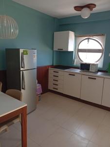 a kitchen with a white refrigerator and a window at Sol Lazareto Mindelo in Prainha