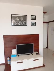 a living room with a television on a white cabinet at Sol Lazareto Mindelo in Prainha