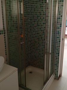 a bathroom with a shower with green tiles at Sol Lazareto Mindelo in Prainha +6 photos