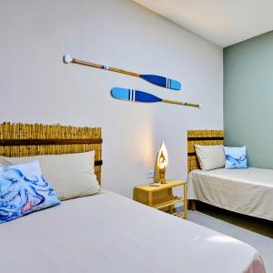 a bedroom with two beds and a lamp at Casas Costa Dos Corais - 200m do mar, Climatizada, Confortável e Completa in Japaratinga