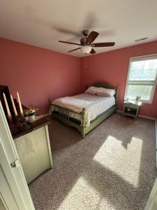 a bedroom with a bed and a ceiling fan at The Bee & Bramble in Raeford