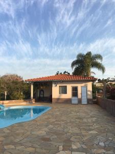 a house with a swimming pool in front of it at Sítio primavera socorro-sp in Socorro