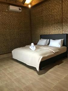 a large bed with a white stuffed animal on it at Nova's Bungalow in Sangyang