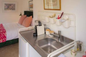 a kitchen sink in a small room with a bed at Finnis Studio in Napier