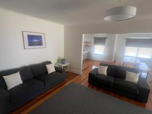 a living room with a black couch and a table at 'Sheffield Central' in Sheffield