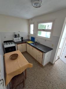 a small kitchen with a table and a sink at Amplio dpto Miramar centro y playa in Miramar