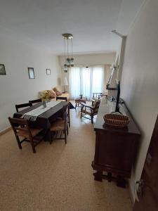 a living room with a dining room table and chairs at Amplio dpto Miramar centro y playa in Miramar