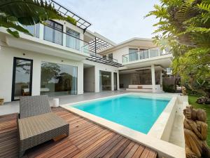 a villa with a swimming pool and a house at Nazeki Villa in Uluwatu