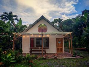 a small house with a porch in a garden at Mystic Solarium Private Indoor Pool in Chachagua