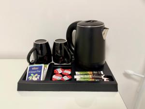 ein schwarzes Tablett mit einer Kaffeekanne und einigen Snacks. in der Unterkunft Traumwelt in Flemlingen