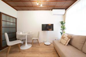 a living room with a couch and a table at KURIHAMA Base 102 in Kubiri