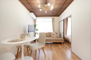 a dining room with a table and chairs and a couch at KURIHAMA Base 102 in Kubiri