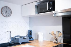 a kitchen with a counter top with a microwave at Instant Pyrénéen in Lourdes