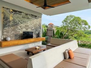 an outdoor living room with a fireplace and a tv at Nazeki Villa in Uluwatu