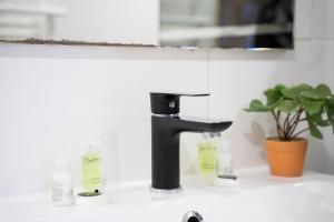 a black faucet on a sink in a bathroom at Instant Pyrénéen in Lourdes +51 photos